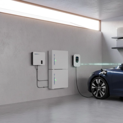 A HANCHU ESS residential battery system installed in a modern garage, showing two stacked battery modules and a wall-mounted inverter connected to an electric vehicle charger powering a blue car.